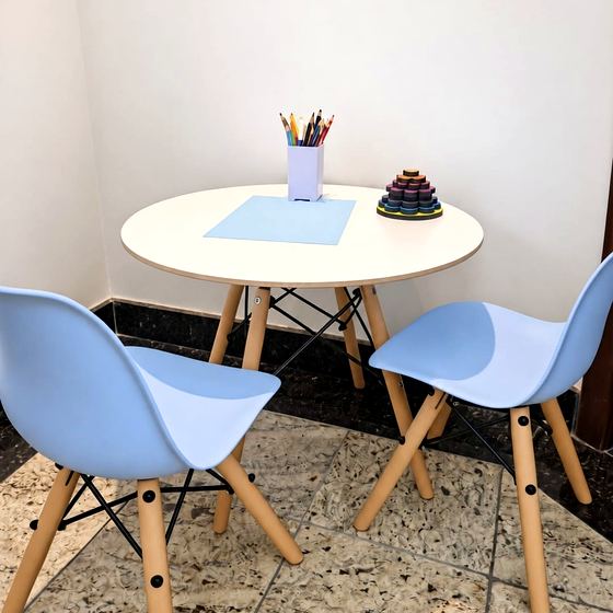 Mesa infantil com cadeiras azuis e material de atividades