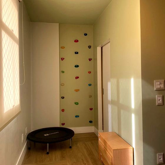 Sala motora com parede de escalada e cama elástica